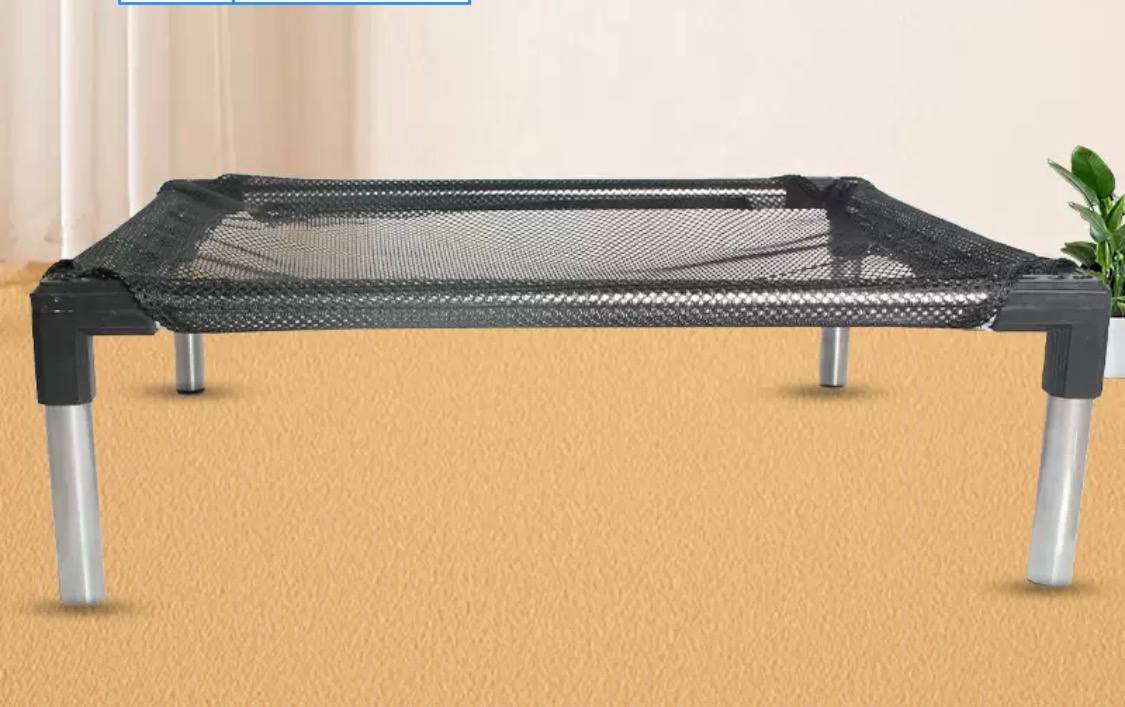 Black mesh table on a beige floor with a neutral background